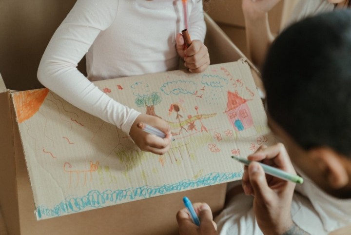 kids drawing on a cardboard box