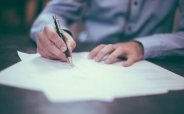 man signing a document