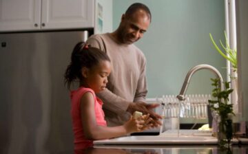 father and daughter washing hands