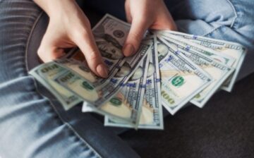 woman holding various currency bills