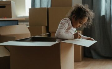 young child in moving box