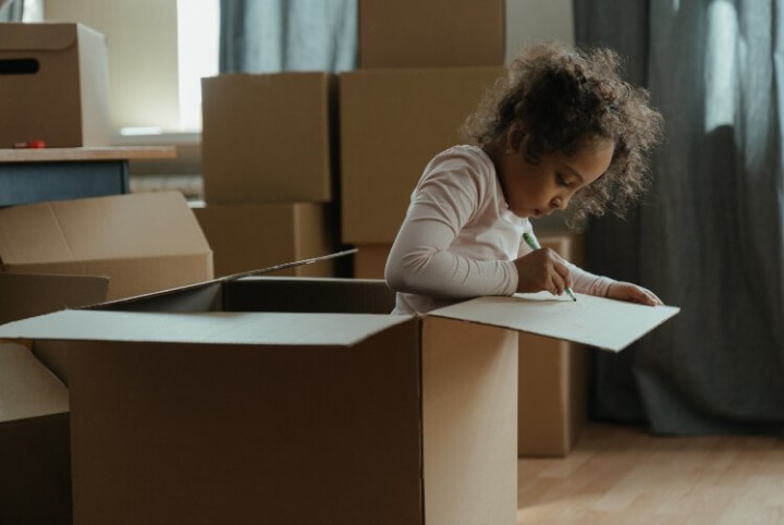 young child in moving box