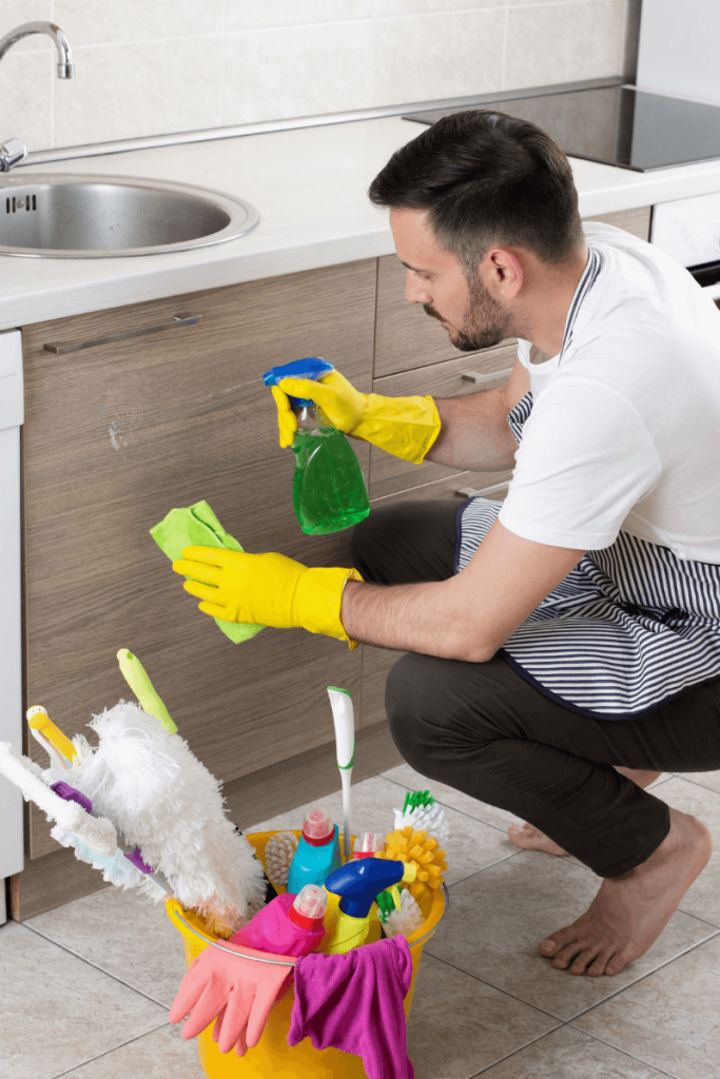 man cleaning kitchen cabinets