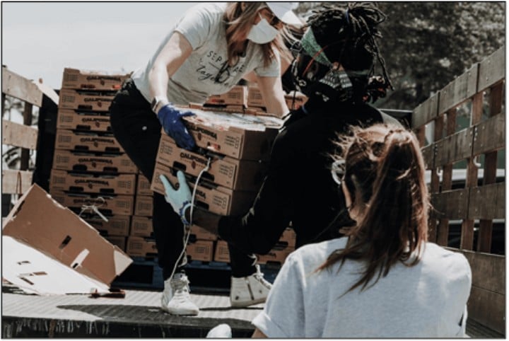 young women loading boxes onto a flatbed truck