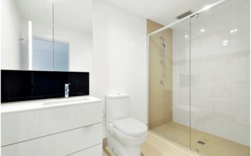 bathroom with large mirror and glass shower wall