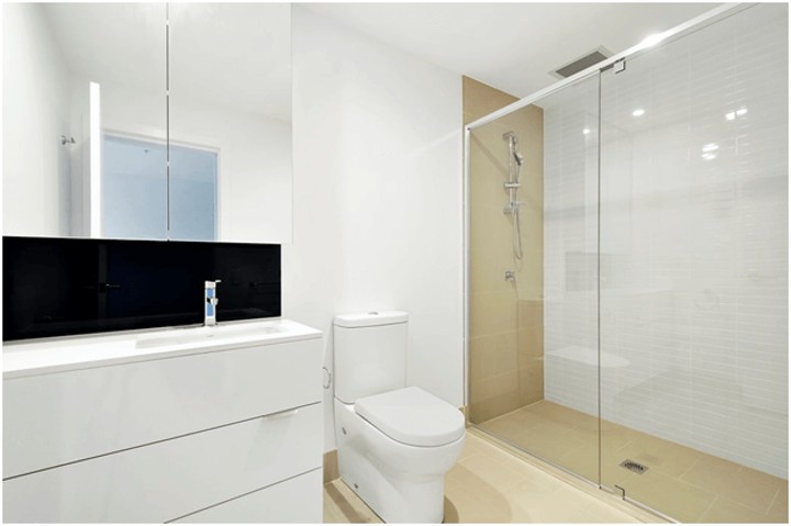 bathroom with large mirror and glass shower wall