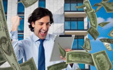 man looking at tablet celebrating earnings from his work
