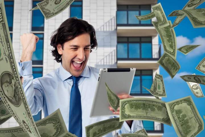 man looking at tablet celebrating earnings from his work