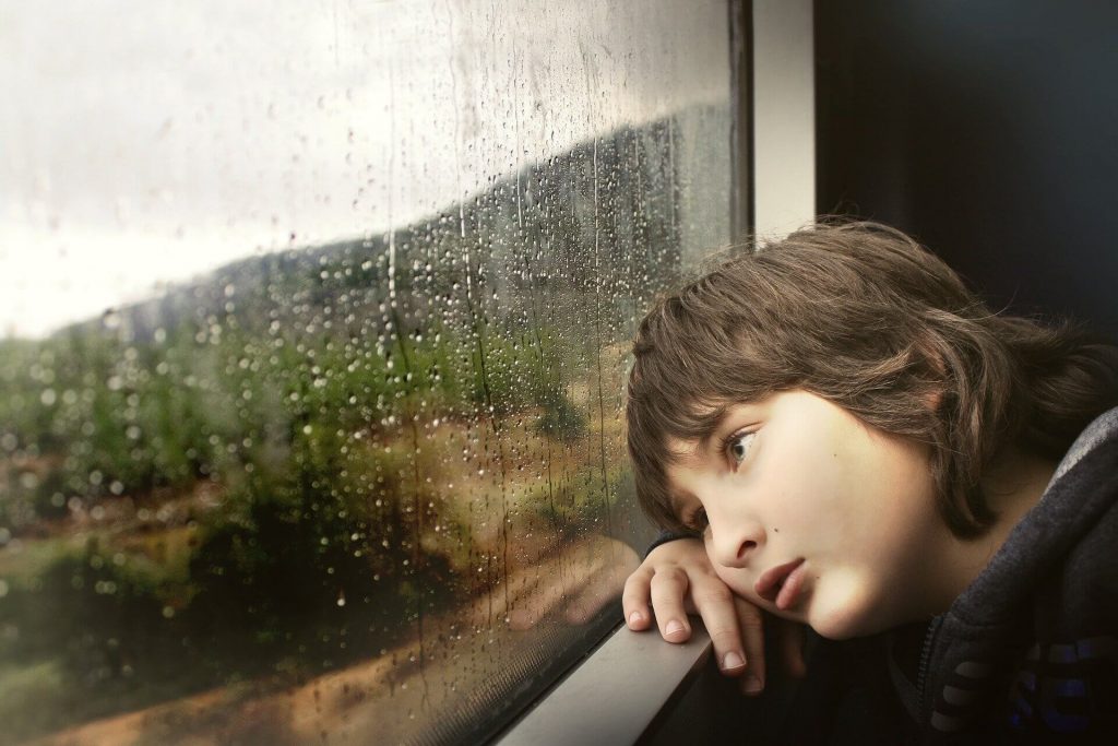 child sitting by a window
