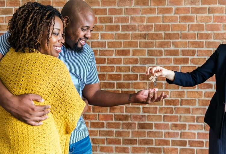 couple receiving keys from realtor