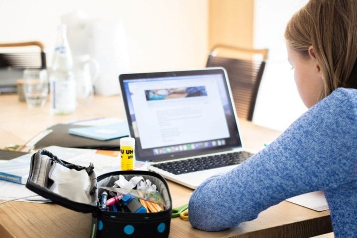 young girl studying on a laptop