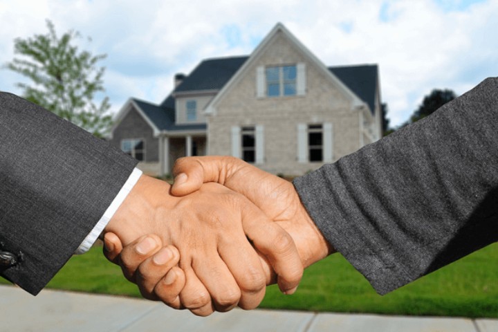 handshake in front of a house