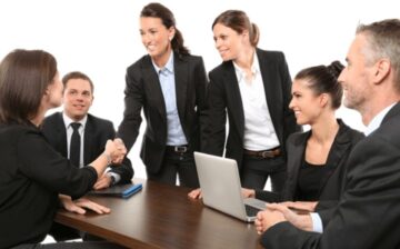 group of business people in dark suits shaking hands