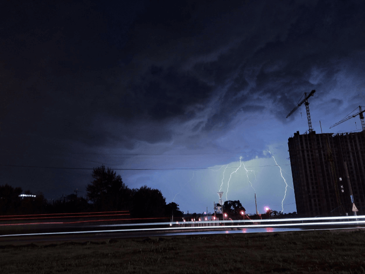 truck driving at night with thunderstorm in background