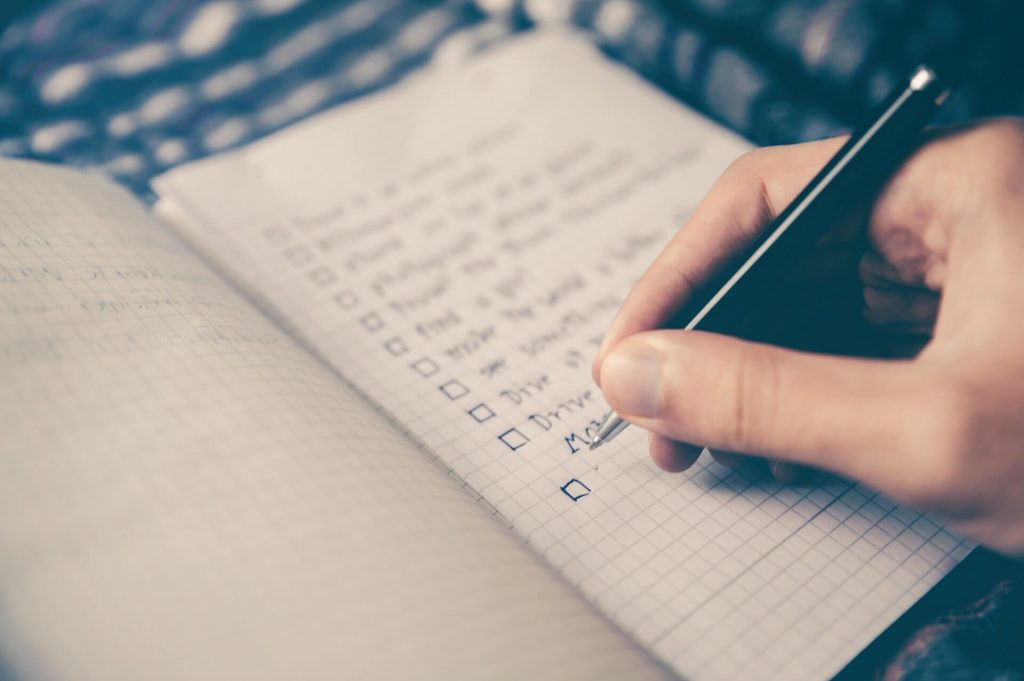 creating a handwritten checklist in a notebook