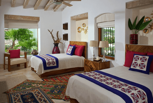 bedroom with colored pillows on the beds and decorations