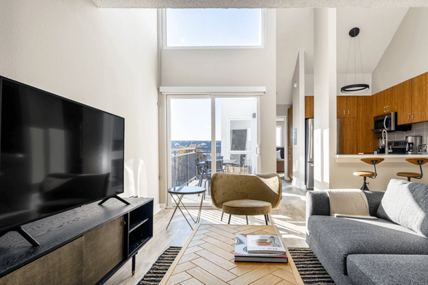 apartment living room with large TV and sliding door to balcony