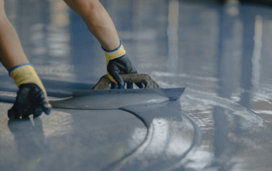 laying down floor coating in a warehouse