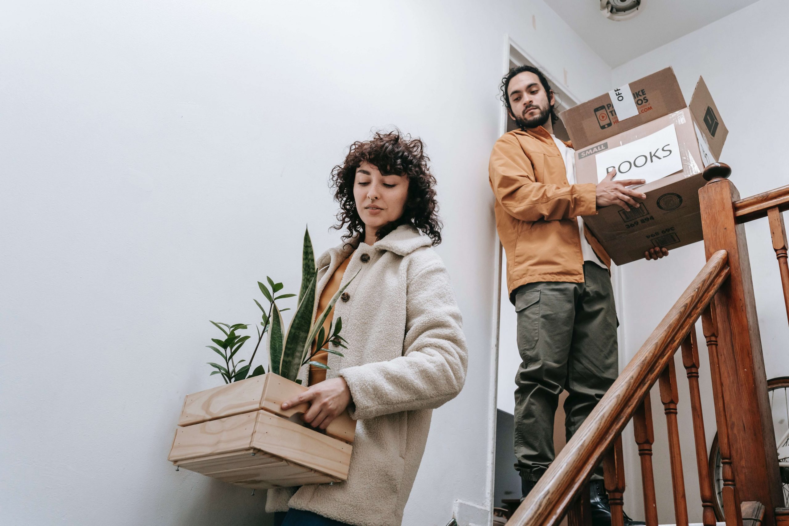 young couple carrying boxes down stairs