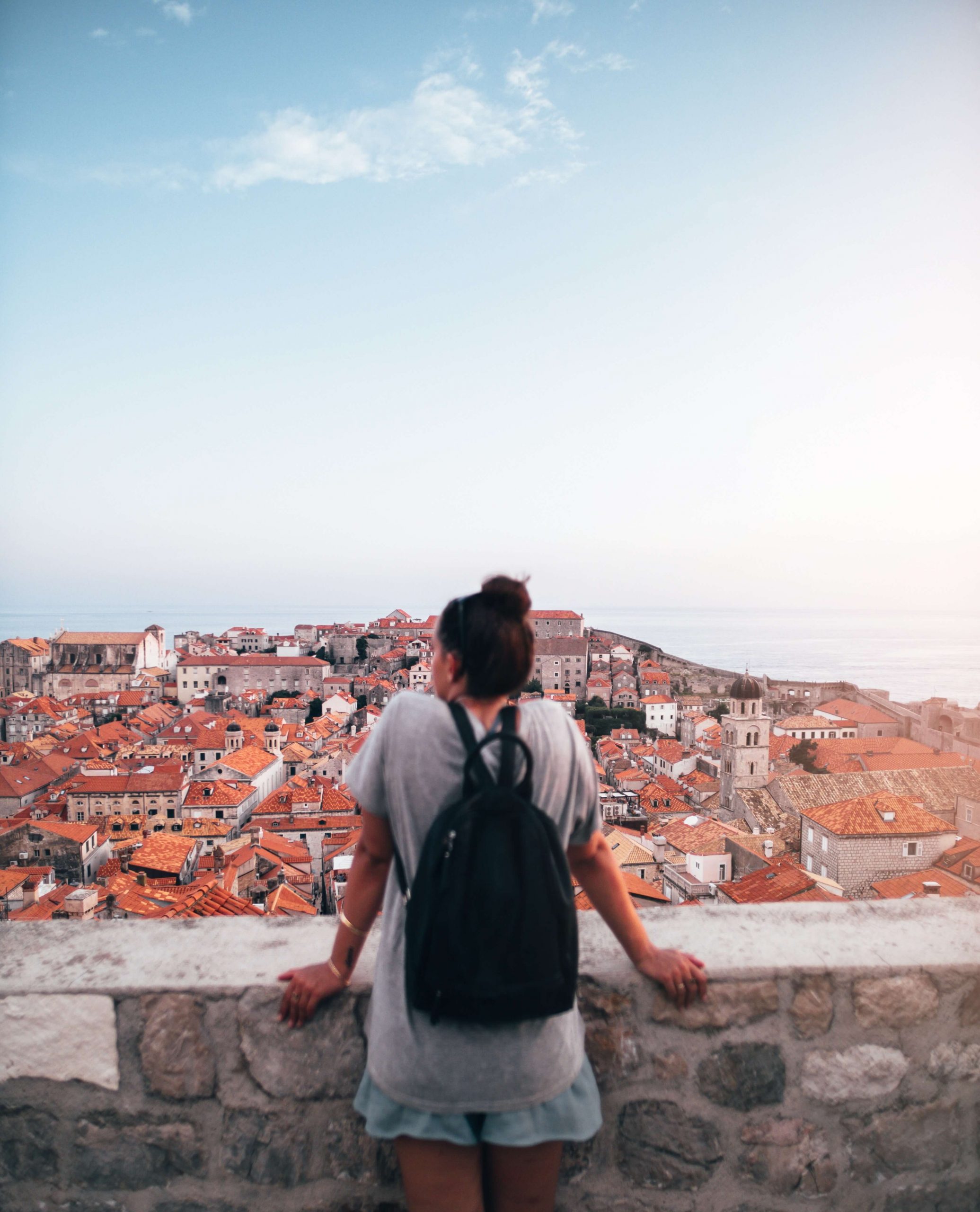 student with backpack overlooking a seaside village