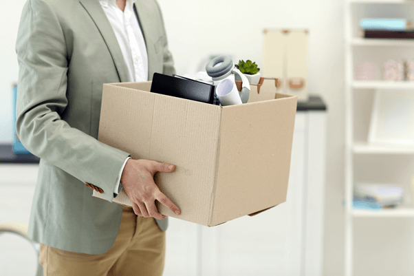 man wearing a blazer and holding a small moving box
