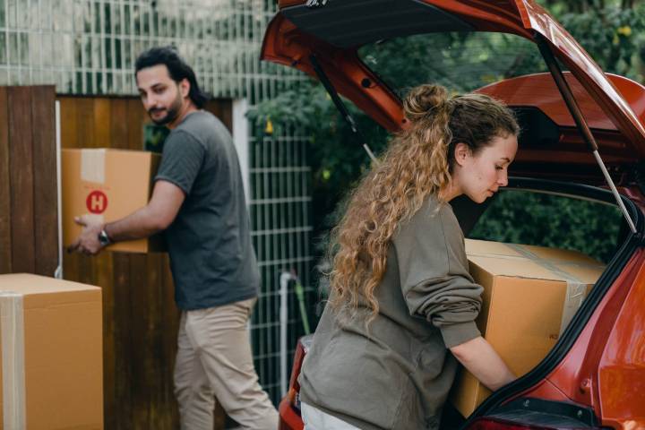 couple loading moving boxes into the car