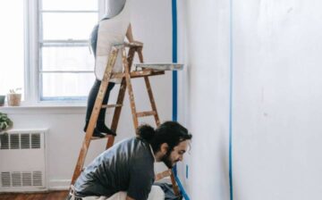 couple painting wall in the house