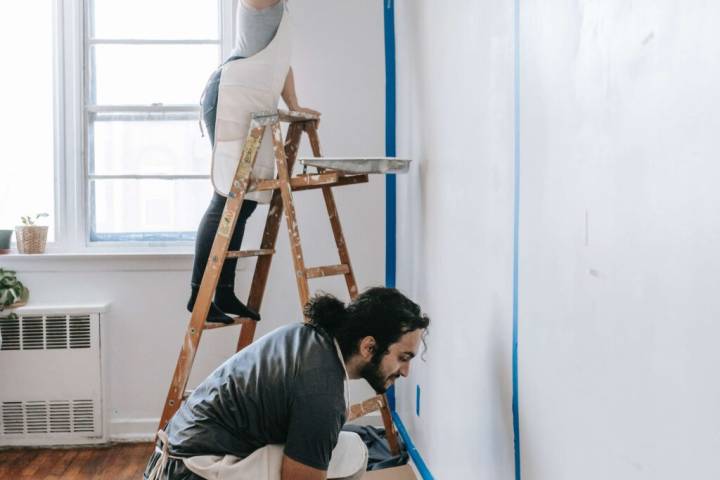 couple painting wall in the house