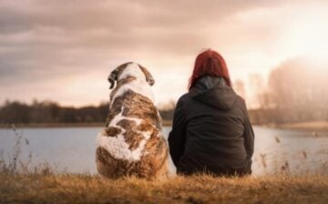 girl with dog at the edge of lake