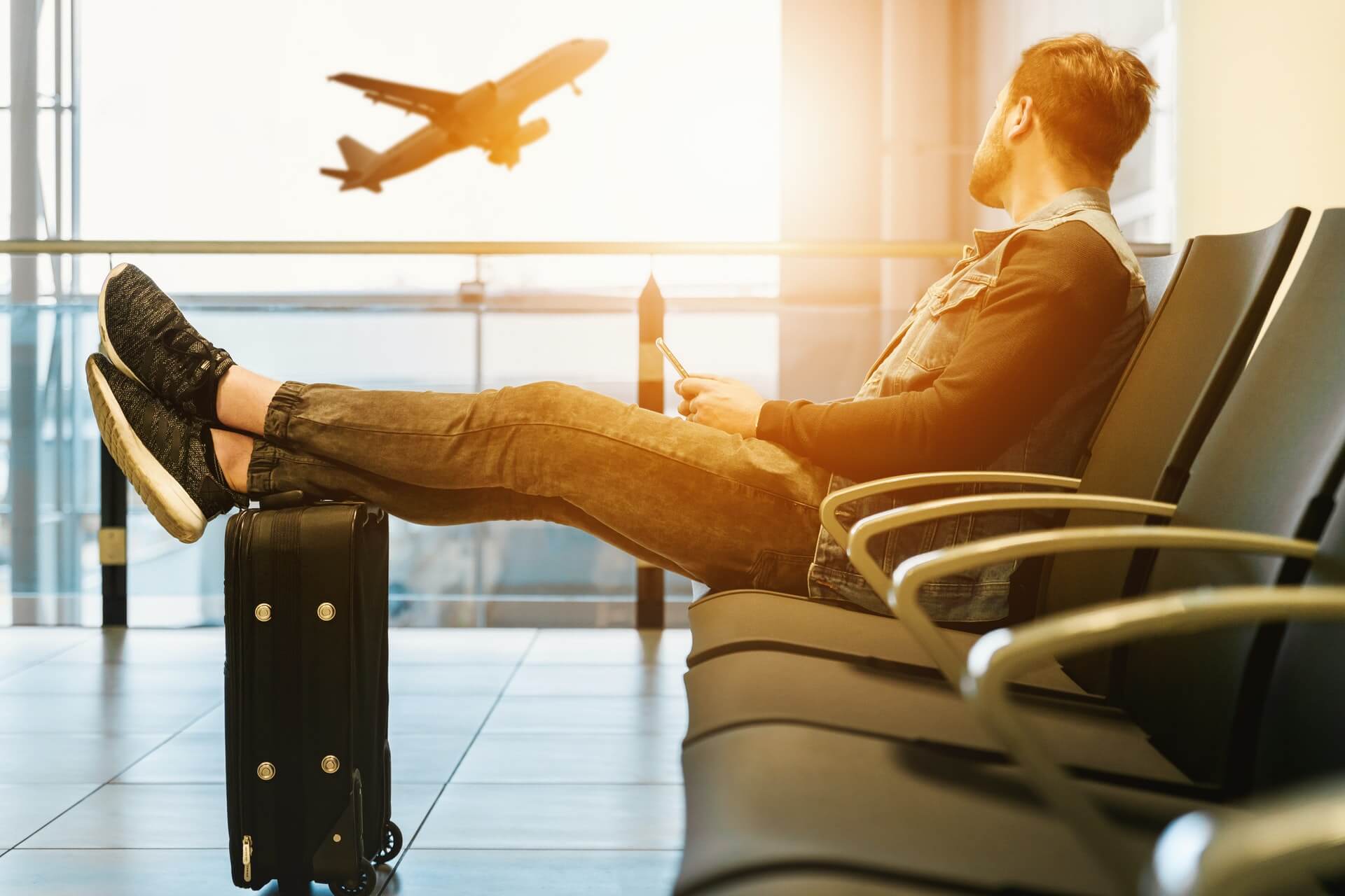 man at airport watching jet taking off