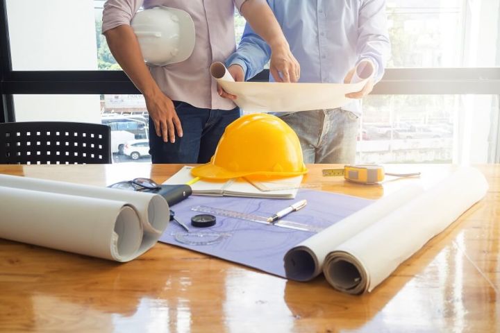 men looking at construction plans of a house