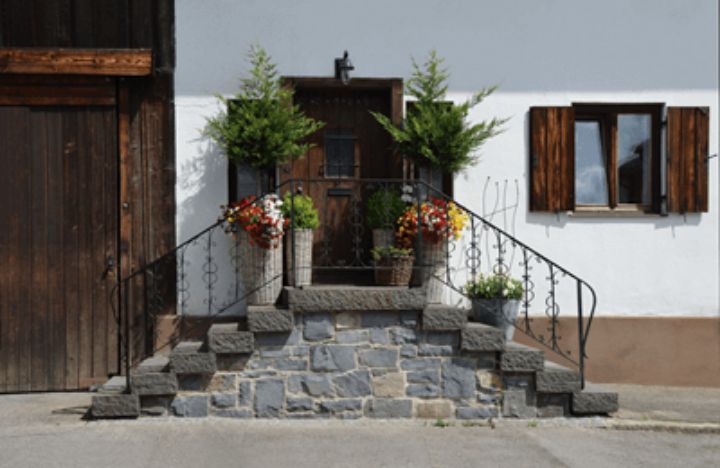 dark brown wooden exterior door with staircases on each side