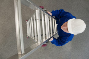 worker climbing a fold-down ladder