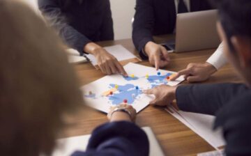 group pointing at a map with points marked