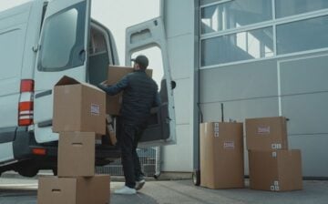 man loading moving boxes into a van