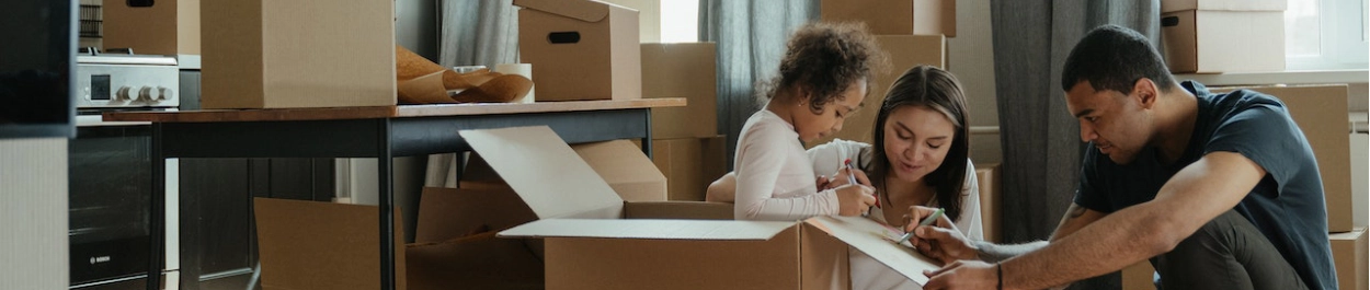 Family packing moving boxes getting ready to move to their new home