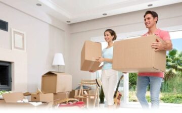 a man an woman holding moving boxes