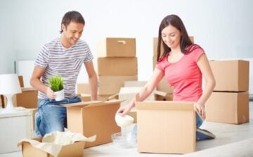 two people seating opening moving boxes