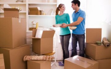 a man and a woman preparing moving boxes