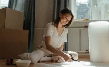 woman seating with moving boxes around