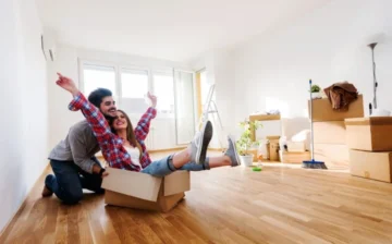 woman seating inside a moving box and a man pushes her