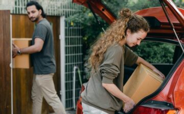 man and a woman loading moving boxes to a car