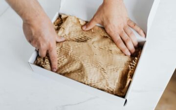 hands packing a package in box