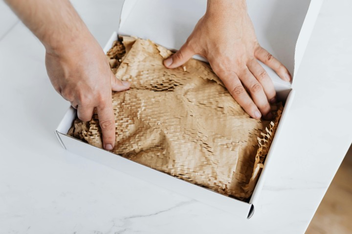 hands packing a package in box