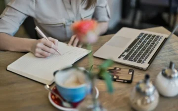 hands writing in diary and computer