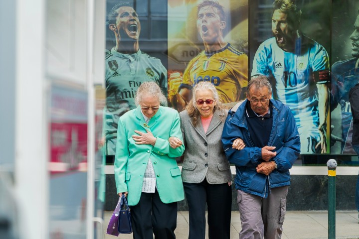 elderly friends walking hugging