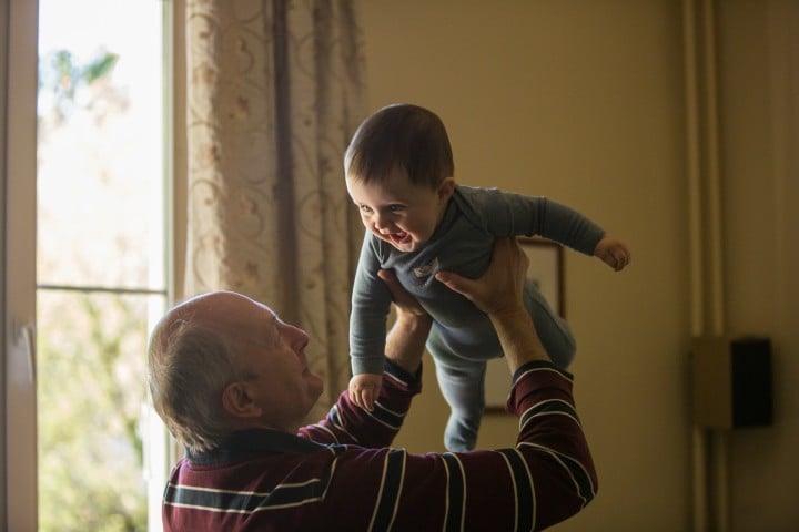 grandparents holding grandson