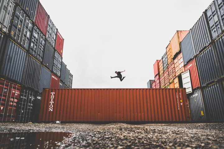 man jumping on top of a container