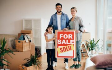 family with house sold sign