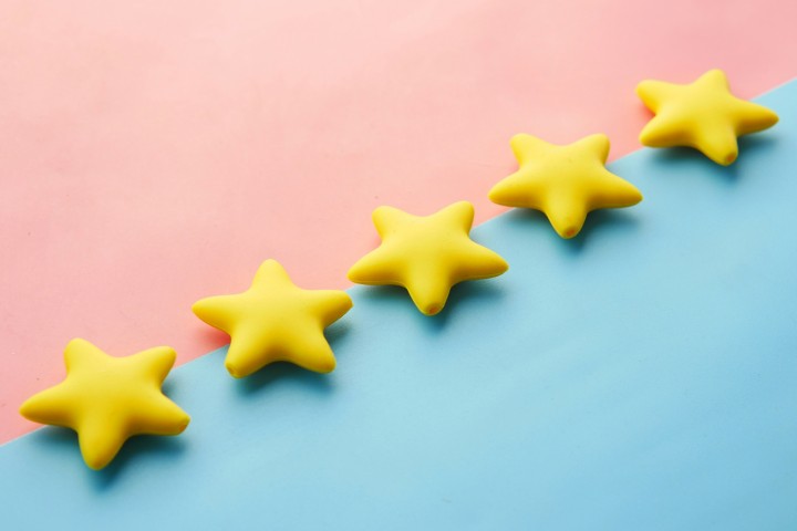 Five stars on a blue and pink surface to symbolize a guide to moving company reviews